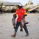A man carries fish as he walks past fishing boats in Dakar, Senegal,